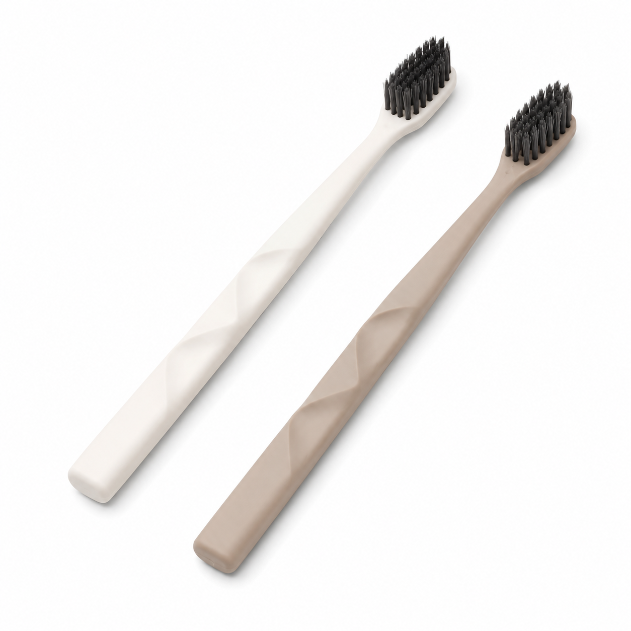 Beige and white hotel toothbrushes with dual-sided textured ergonomic handles on white background