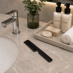black hotel comb placed in luxury bathroom amenities setting