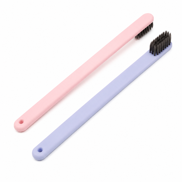 Korean style disposable hotel toothbrushes in pink and lavender colors on white background