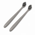 Minimalist grey hotel toothbrushes with soft bamboo charcoal bristles on white background