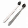 Grey and white hotel toothbrushes with ergonomic wavy anti-slip handles on white background